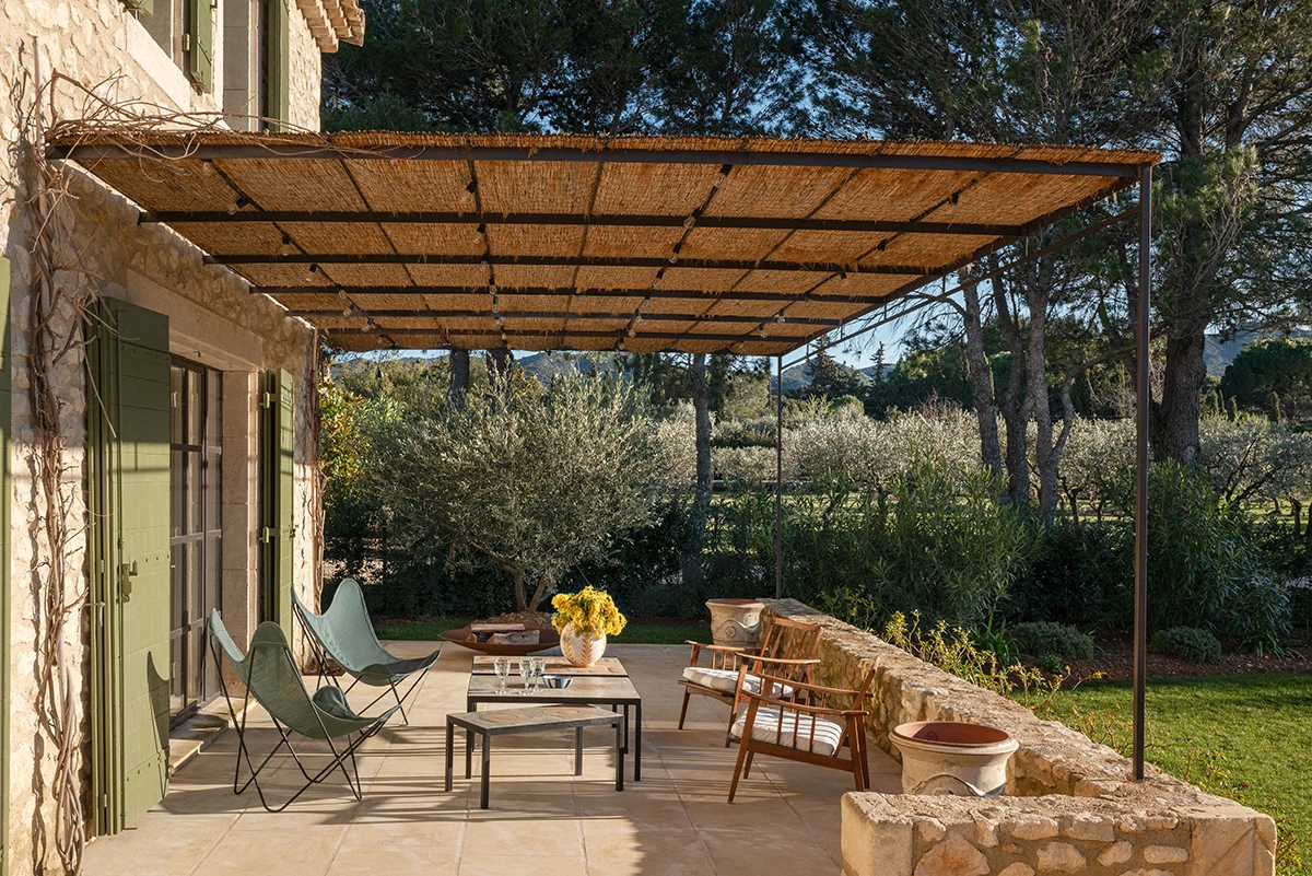 Zona za opuštanje pod pergolom ili ispred kućice uz bazen, s naslonjačima i ležaljkama od prirodnih materijala